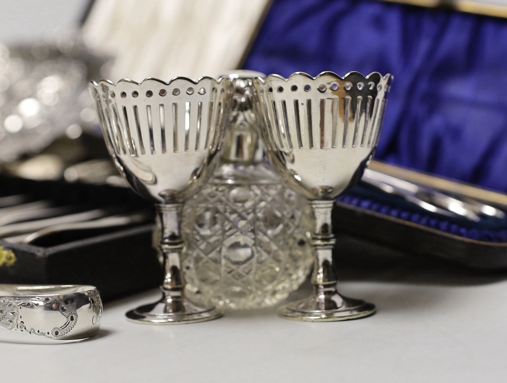 Sundry small silverwares including flatware, a pair of mounted glass scent bottles, a white metal German dish and minor plated items.